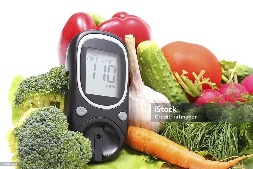 Glucose meter and fresh vegetables on wooden cutting board Glucose meter and fresh ripe raw vegetables lying on wooden cutting board, desk of healthy organic vegetables, concept for healthy eating and diabetes. Isolated on white background Blood Stock Photo
