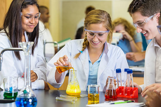 istock Teens mixing chemicals during science experiment in classroom 504546495