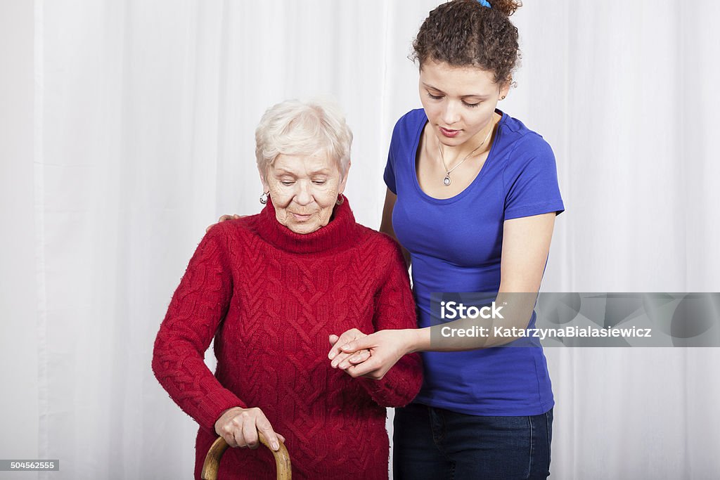 Granddaughter helping grandmother Horizontal view of granddaughter helping her grandmother Adult Stock Photo