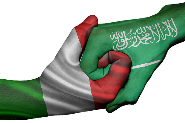 Diplomatic handshake between countries: flags of Italy and Saudi Arabia overprinted the two hands