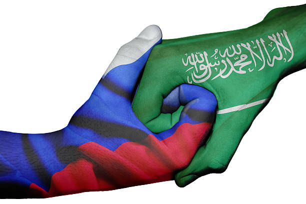 Diplomatic handshake between countries: flags of Russia and Saudi Arabia overprinted the two hands