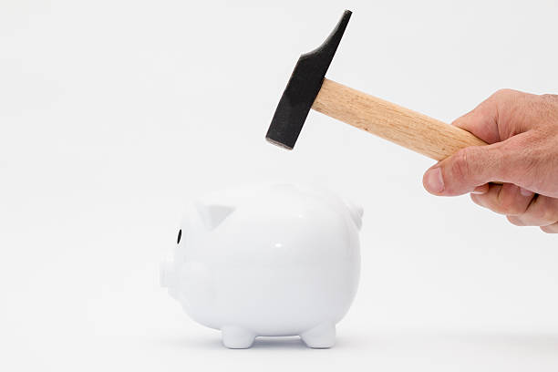 piggy bank and a man's hand hitting it with a hammer piggy bank and a man's hand hitting it with a hammer in a white background ganar stock pictures, royalty-free photos & images