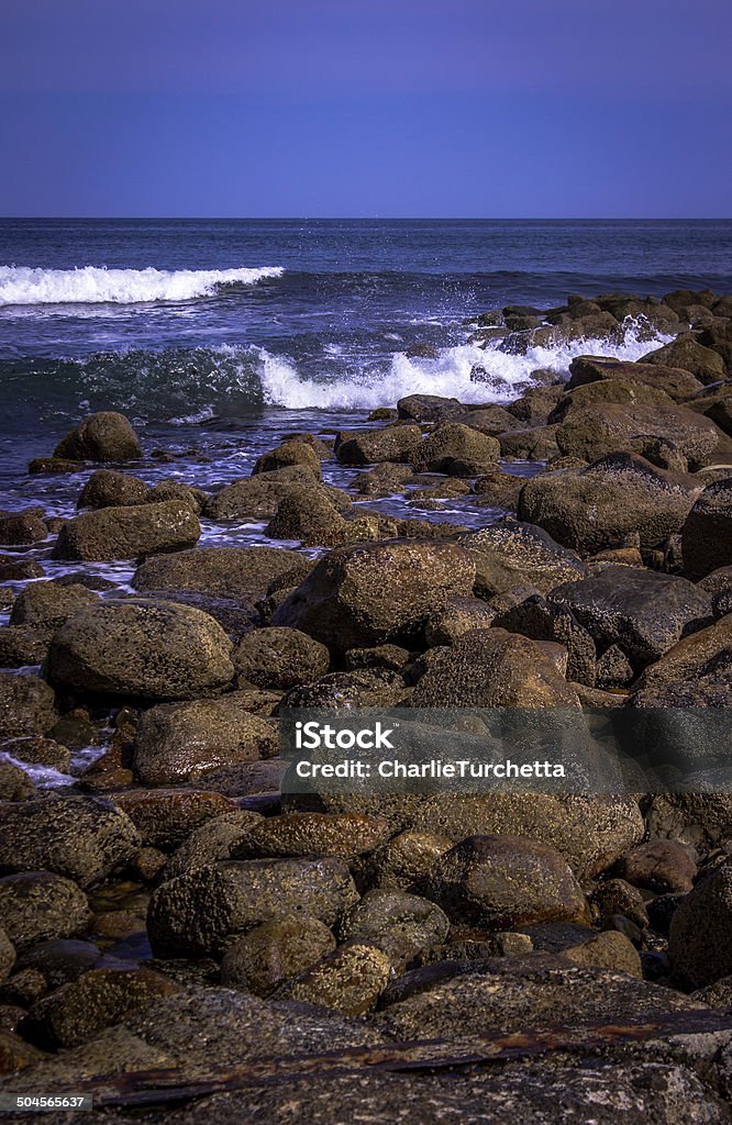 Rocky Beach Water crashing over a rocky beach. Bay of Water Stock Photo
