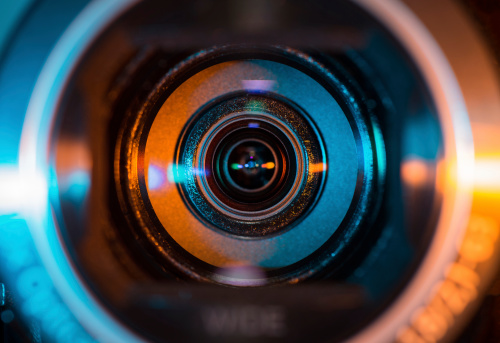 Video camera lens lit in blue and orange