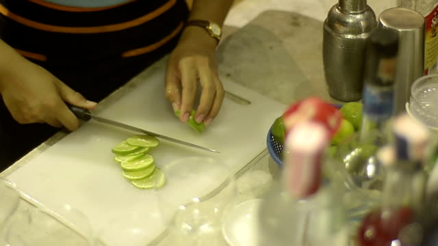 bartender preparing lime for use with cocktail