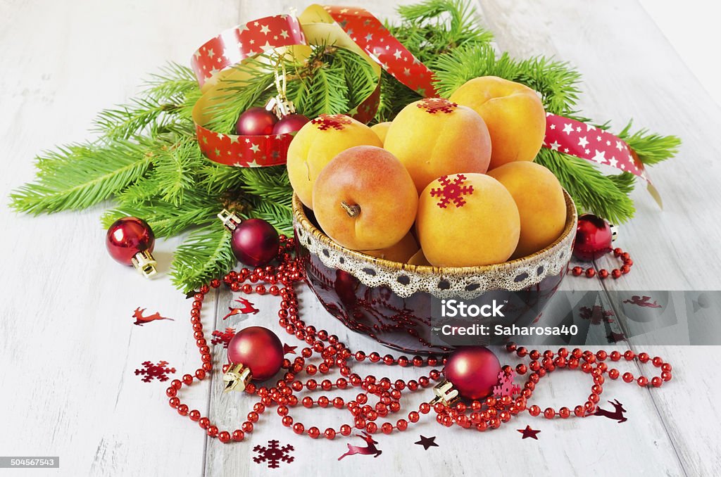 apricots and christmas decorations apricots in a bowl and christmas decorations on a table.selective focus Apricot Stock Photo