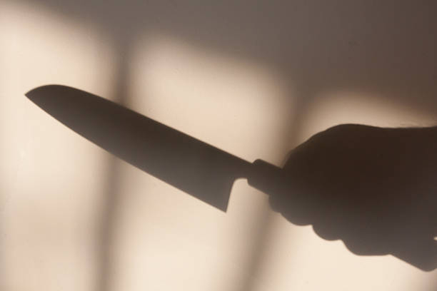 istock shadow of a hand with a knife 504572714