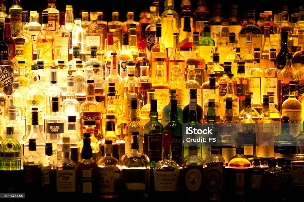 Various Liquor bottles backlit. Various liquor bottles sitting behind bar, backlit Alcohol - Drink Stock Photo
