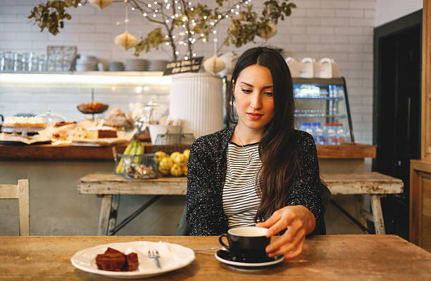istock Young brunette having a coffee and a chocolate cake 504576972