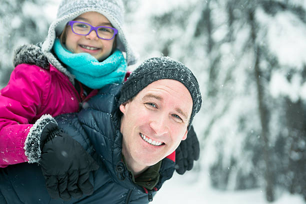istock Father and daughter enjoying snow at daytime 504577028