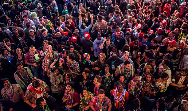 Faces of Mardi Gras (Bourbon Street, New Orleans) A large crowd of Mardi Gras revelers fill Bourbon Street in New Orleans, Louisiana. new orleans mardi gras stock pictures, royalty-free photos & images