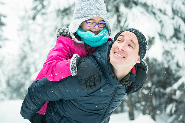 istock Father and daughter enjoying snow at daytime 504577360