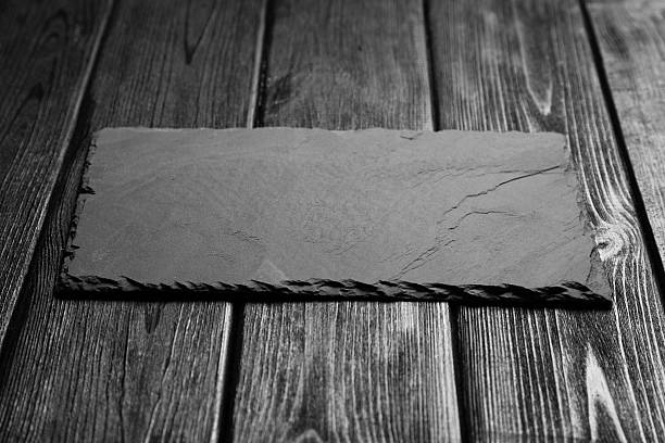 istock Black slateboard on dark wood 504577570