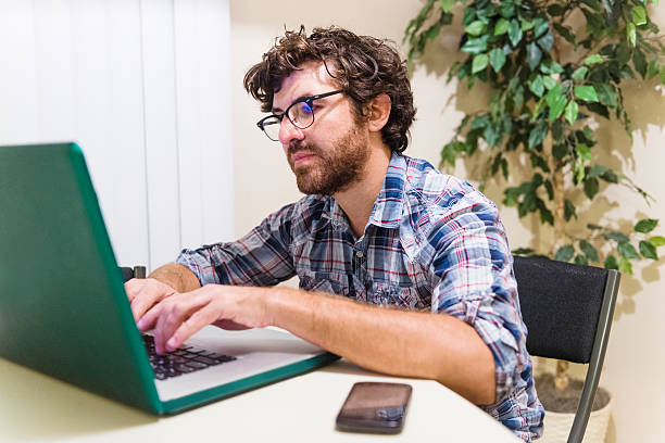 istock Smart American Man with Beard and Glasses Writes on Laptop 504580152