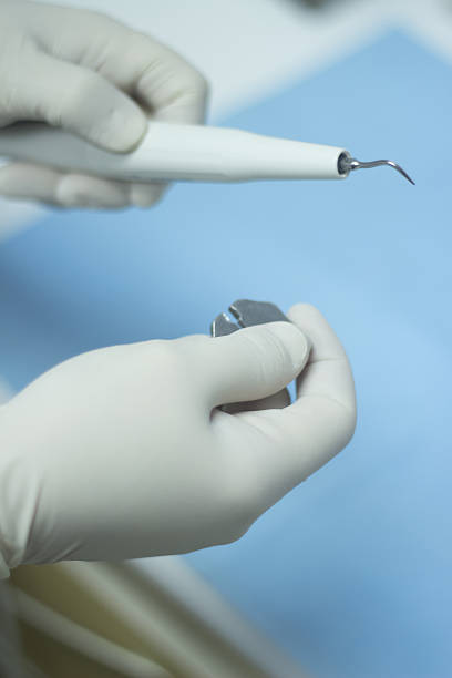 istock Dental nurse attaching ultrasound teeth cleaning attachment 504580373