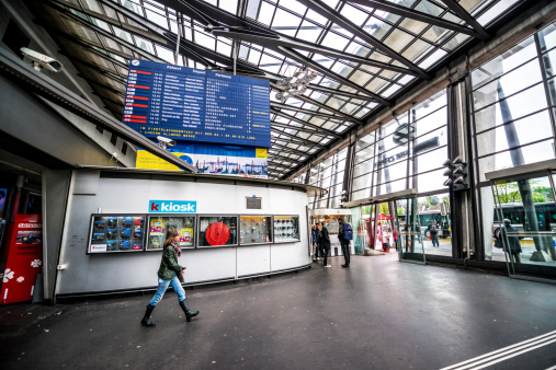 Lucerne, Switzerland - May 2, 2014: Lucerne railway station, Bahnhof Luzern, Switzerland. Newspaper kiosk, people walking.