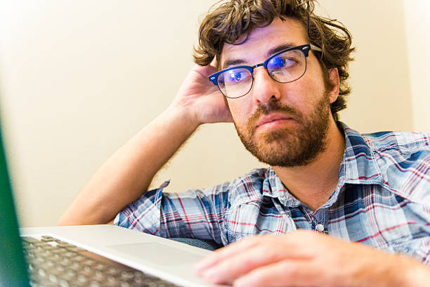 istock Serious American Man Studying Researches Online with Laptop Computer 504581196