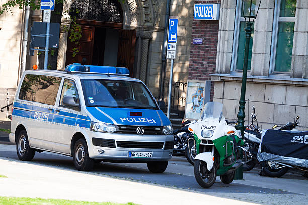 Düsseldorf, Germany - July 18, 2014: A van of German police and a motorcycel are standing in front of police station in Düsseldorf Oberkassel. In background some motorcycles are parked.