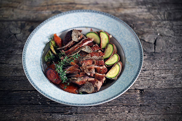 Duck breast sliced with black truffles and vegetables, thyme stock photo