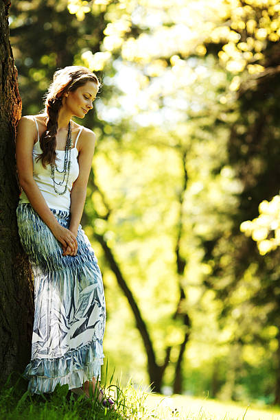 istock girl standing next to a tree 504586677