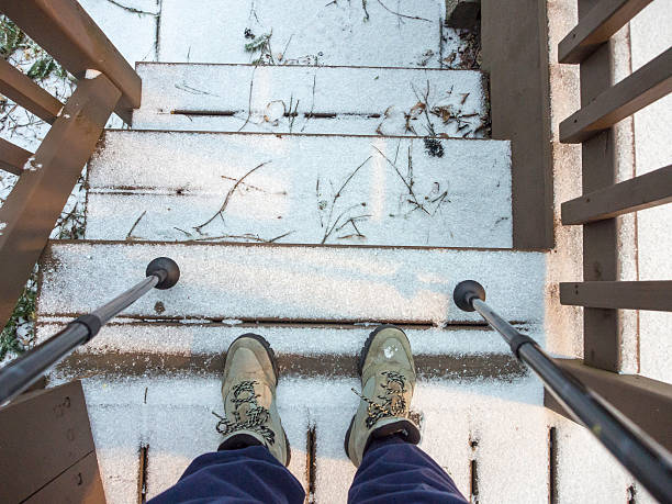 istock Hiker's boots and sticks on stairs with snow 504587946