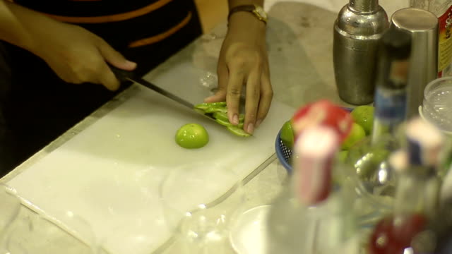 bartender preparing lime for use with cocktail