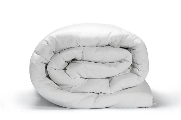 Warm and confortable folded white quilt on white background