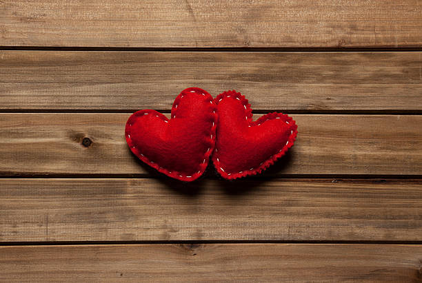 Dois corações vermelhos de algodão em pranchas de madeira - foto de acervo