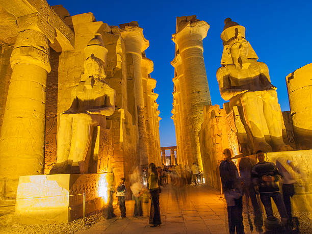 Luxor, Egypt - February 8, 2008: People exploring the Temple of Luxor in Egypt at night.
