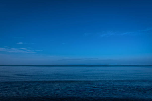 ruhigen ozean und dunkle in der dämmerung - horizont über wasser stock-fotos und bilder