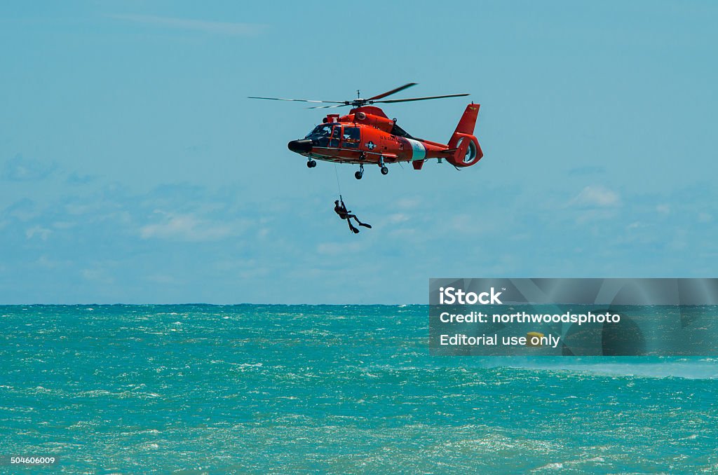 Coast Guard Rescue Helicopter Demonstration Milwaukee, Wisconsin, USA - August 11, 2012: US Coast Guard MH-65 Dolphin diver rescue demonstration on Lake Michigan at the Milwaukee Air Show. Air Vehicle Stock Photo