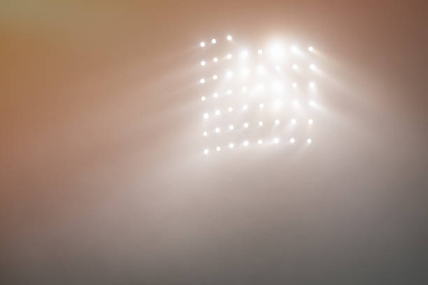 istock Bright white and yellow Stadium lights with fog 504611462