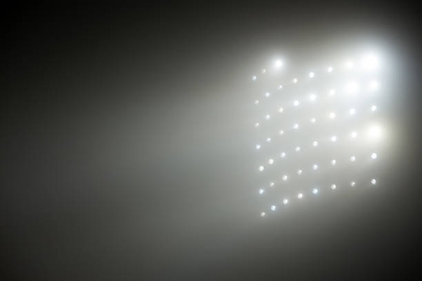 istock Bright white and yellow Stadium lights with fog 504612234