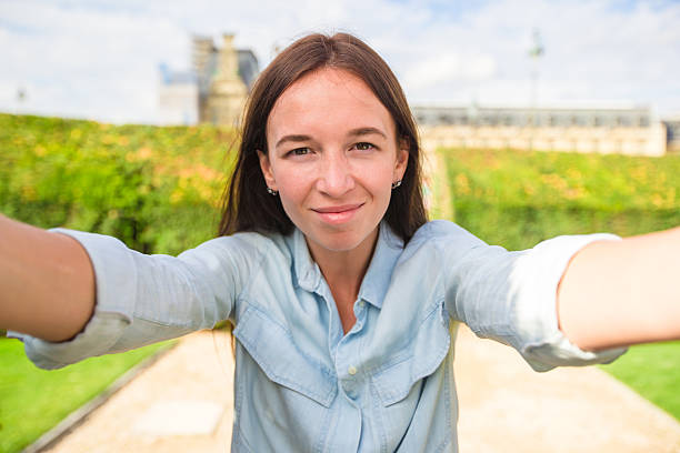 istock Young woman taking selfie with mobile phone outdoors in Paris 504616048