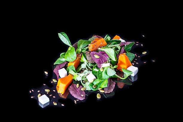 istock Fresh vegetables salad with reflection on a black background, le 504616764