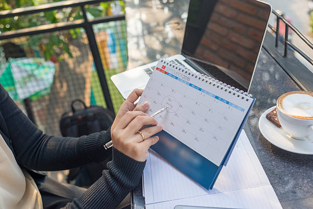 señalando el calendario de pluma para recordar sobre la reunión. - note pad notebook ring binder letter fotografías e imágenes de stock