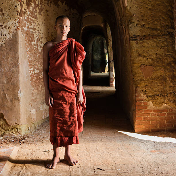 Novice Buddhist monk standing inside the temple