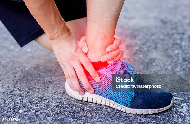 Runner Touching Painful Twisted Or Broken Ankle Runner Training Accident Stock Photo - Download Image Now