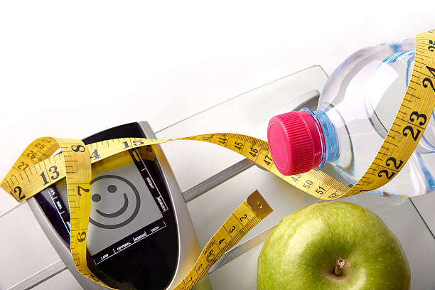 istock Face scale with bottle apple and tape measure top 504638734