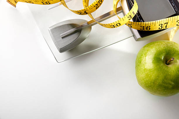 istock Scale with apple and tape measure horizontal composition top 504639528