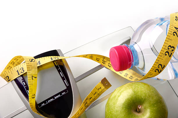 istock Scale with bottle apple and tape measure top 504639710