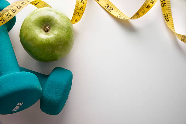 istock Dumbbells with apple and tape measure top 504640656