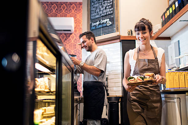 Coffee shop Owners getting ready the food display for the clients at a coffee shop. cafe sandwich stock pictures, royalty-free photos & images