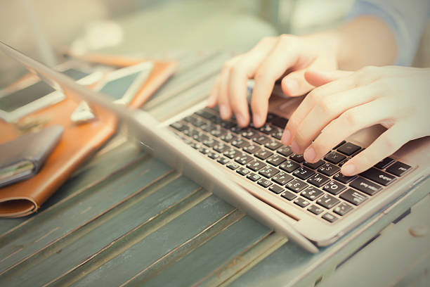 manos escribiendo en computadora portátil-trabajar en ningún concepto (selective focus - generic currency fotografías e imágenes de stock