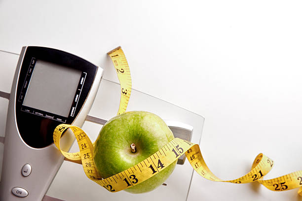 istock Nutrition weight control concept with scale ribbon and apple top 504642284