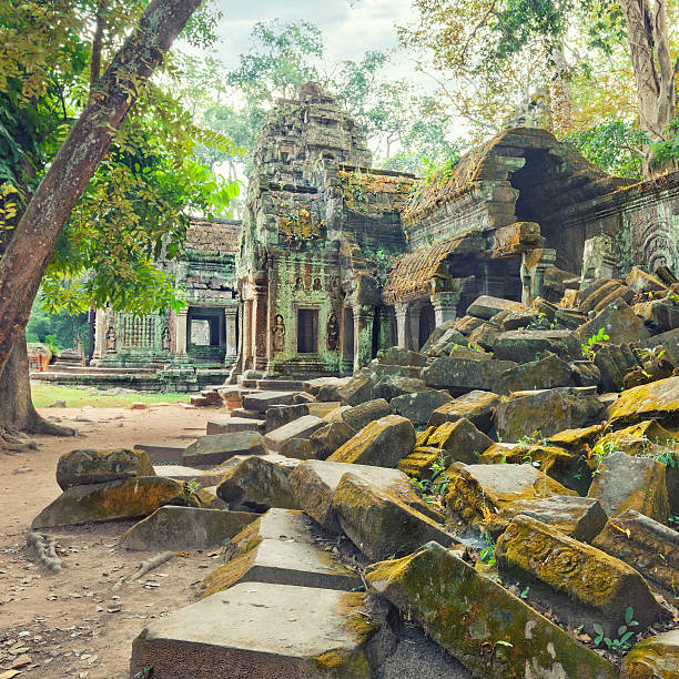 Wide view of moss-covered Ta Prohm temple ruins in Angkor, Cambodia, with collapsed stones and jungle trees. Perfect for travel, history, culture, archaeology, and heritage promo concepts.