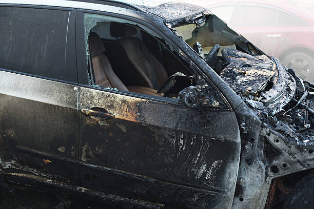 istock Accident or arson burnt car on the road closeup 504645828