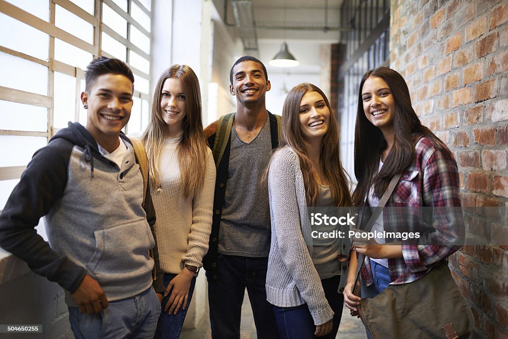 Hanging out after class Portrait of a group of students standing in a college hallway University Student Stock Photo