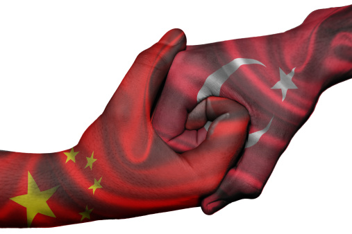 Diplomatic handshake between countries: flags of China and Turkey overprinted the two hands