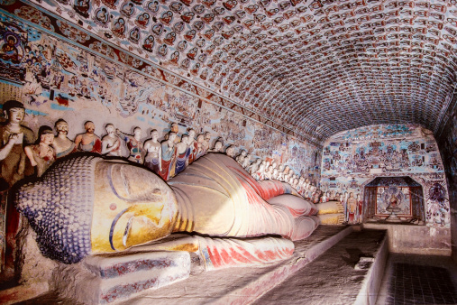 reclining buddha gold statue at mogao caves in the desert near dunhuang,china.A UNESCO world heritage site.